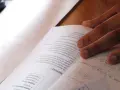 Main d'un étudiant sur un livre de maths, concentré sur le sujet maths jour 2. Formules et exercices à résoudre.