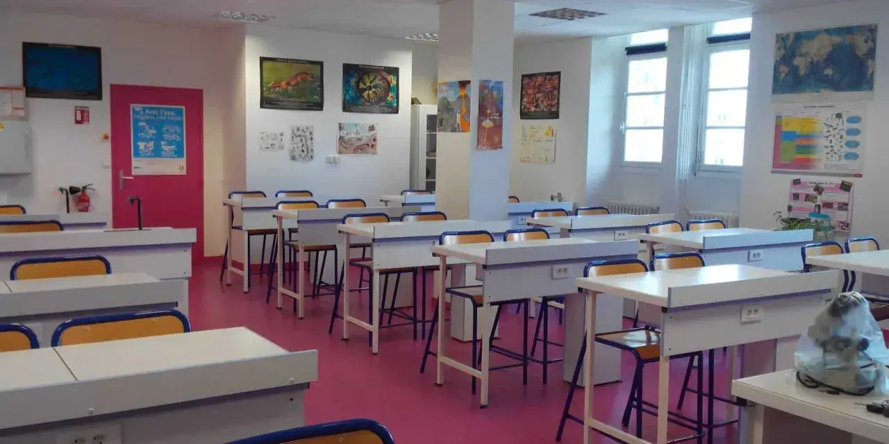 Salle de classe lumineuse avec des tables de laboratoire, des chaises et des posters scientifiques, prête pour l'enseignement scientifique.